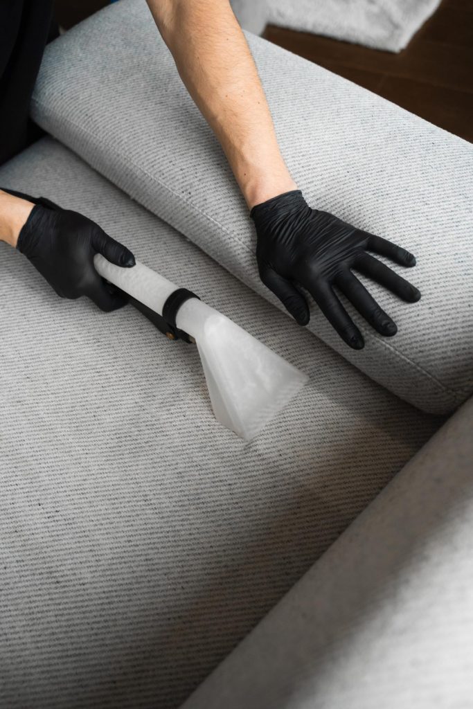 Professional extraction cleaning on a light grey sofa